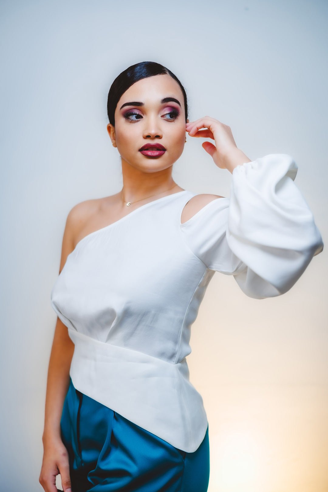 Mujer con la blusa Aitana blanca asimétrica y manga globo, edición limitada hecha en España