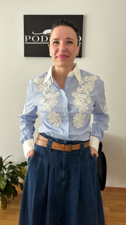 Mujer luciendo camisa de rayas azul y blanco con encaje floral, representando elegancia y estilo atemporal de PODENCO.