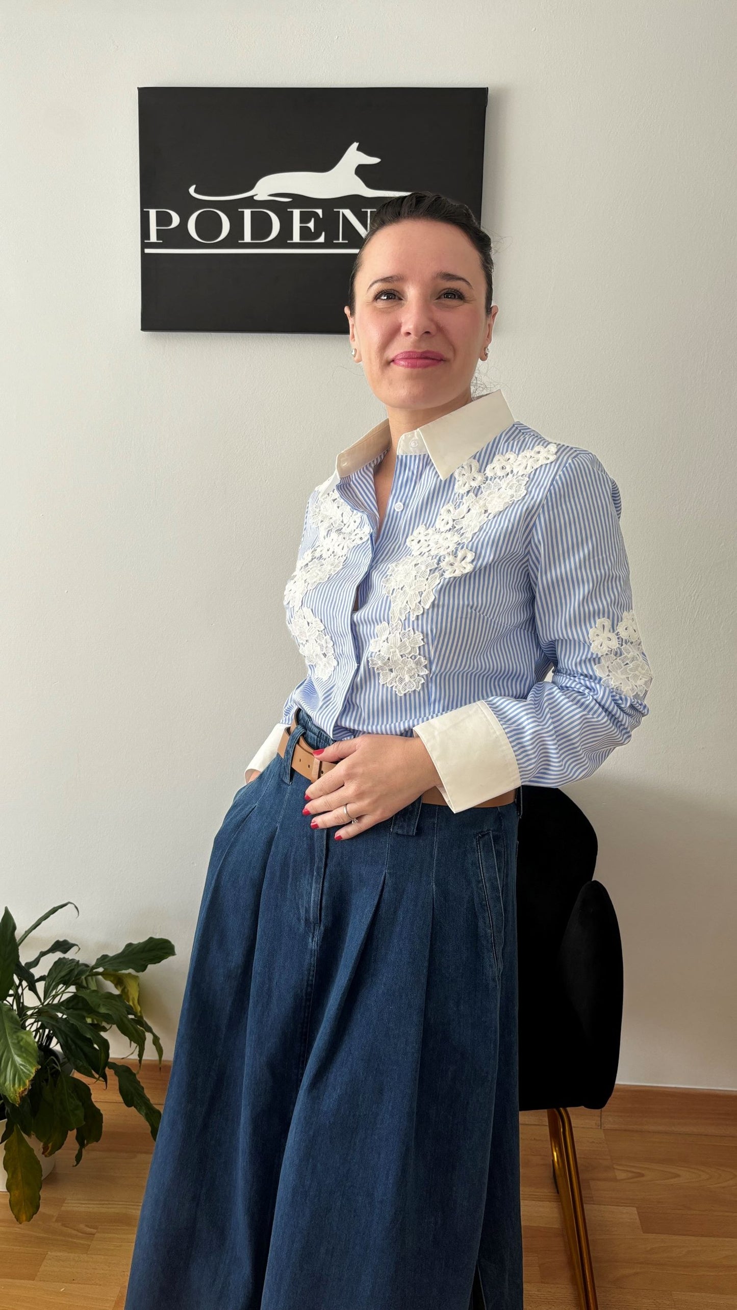 Mujer luciendo camisa de rayas azul y blanco con encaje floral, representando elegancia y estilo atemporal de PODENCO.