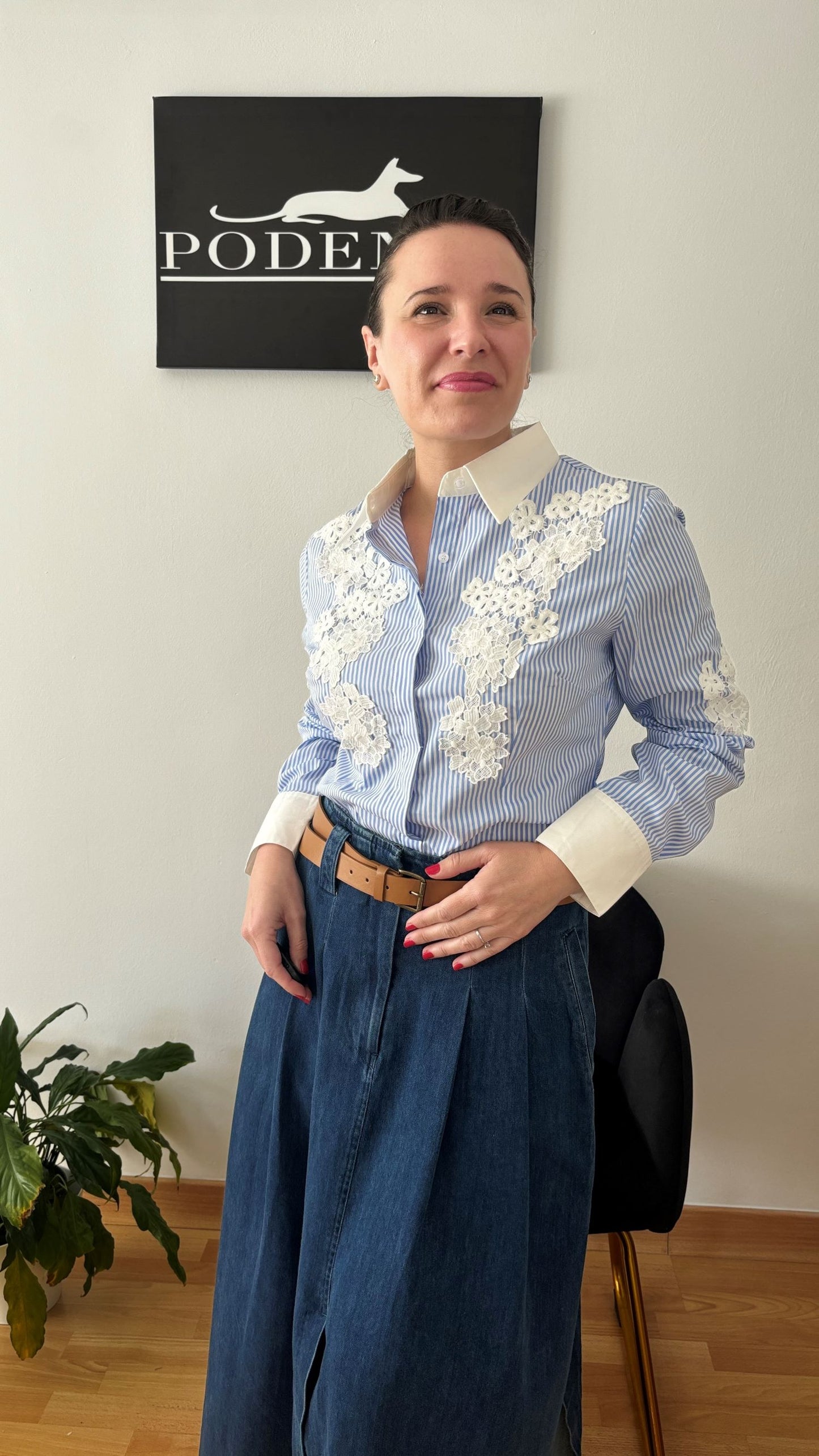 Mujer luciendo camisa de rayas azul y blanco con encaje floral, representando elegancia y estilo atemporal de PODENCO.
