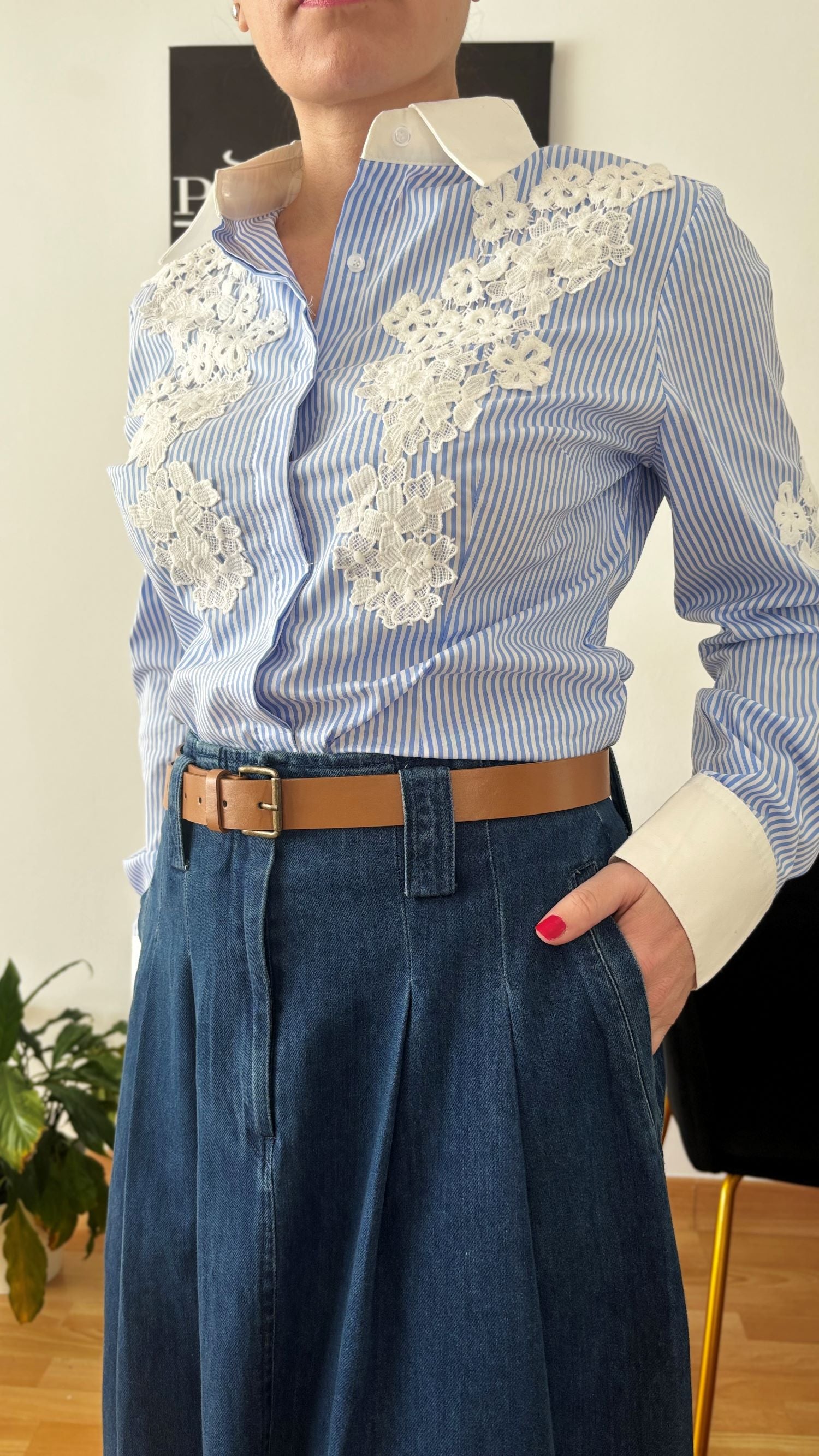 Mujer luciendo camisa de rayas azul y blanco con encaje floral, representando elegancia y estilo atemporal de PODENCO.