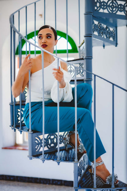 Mujer con la blusa Aitana blanca asimétrica y manga globo, edición limitada hecha en España