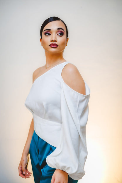 Mujer con la blusa Aitana blanca asimétrica y manga globo, edición limitada hecha en España